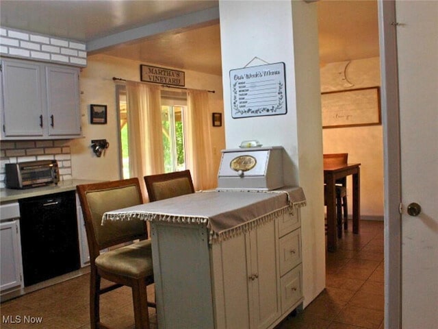 8240 Bellflower Rd, Mentor, OH 44060 - kitchen with dishwasher, a kitchen bar, dark tile patterned flooring, and light countertops