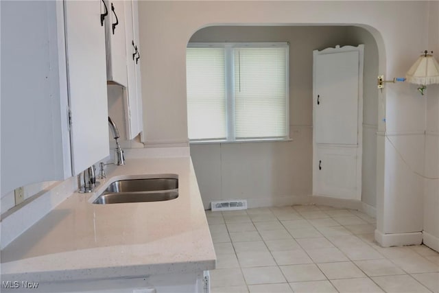 3400 W 118th St, Cleveland, OH 44111 - kitchen featuring light tile patterned floors, light stone counters, and white cabinetry