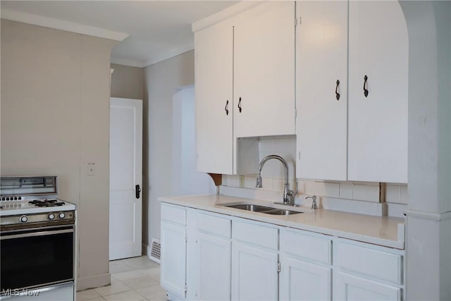 3400 W 118th St, Cleveland, OH 44111 - kitchen featuring white range with gas stovetop, light countertops, backsplash, and white cabinets
