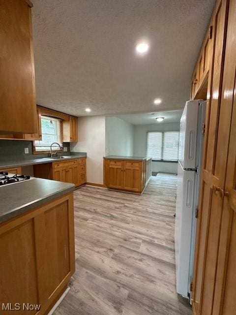 362 E 47th St, Lorain, OH 44052 - kitchen with freestanding refrigerator, light wood-type flooring, recessed lighting, dark countertops, and a textured ceiling