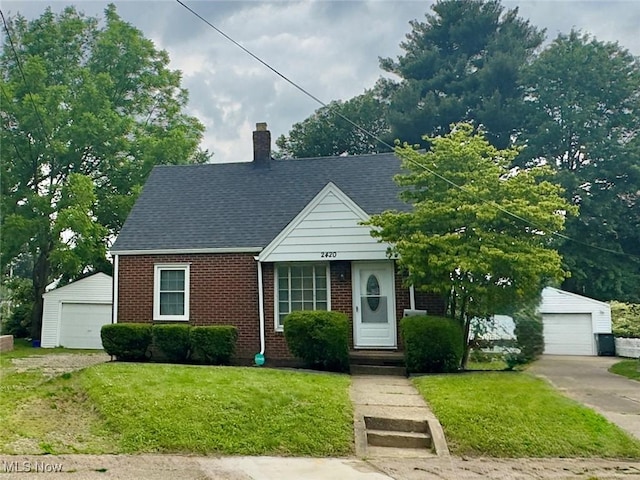 2420 Empire Rd NE, Canton, OH 44705 - view of front facade featuring an outdoor structure, brick siding, a garage, and a front lawn