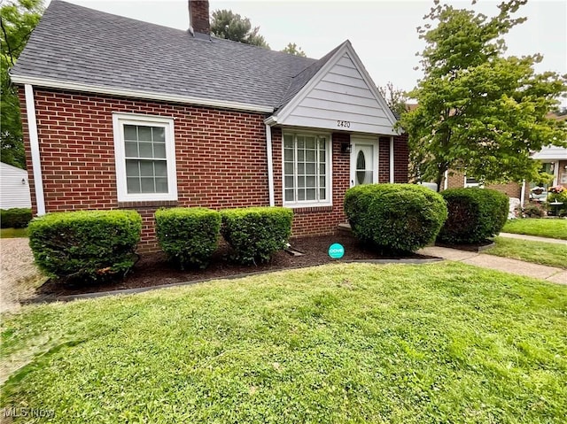 2420 Empire Rd NE, Canton, OH 44705 - view of front of property with brick siding, a chimney, and a front lawn