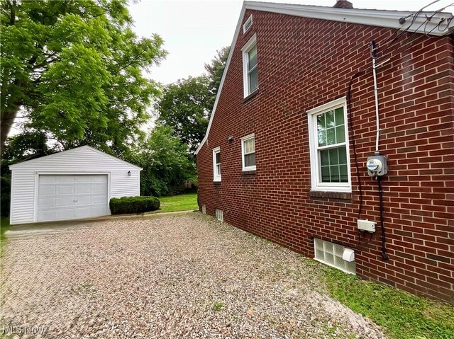 2420 Empire Rd NE, Canton, OH 44705 - view of home's exterior with an outbuilding, brick siding, gravel driveway, and a garage