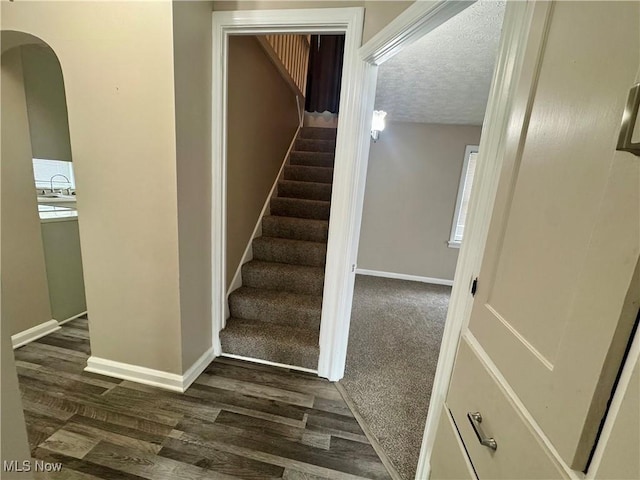 2420 Empire Rd NE, Canton, OH 44705 - stairway featuring wood finished floors, arched walkways, and a textured ceiling