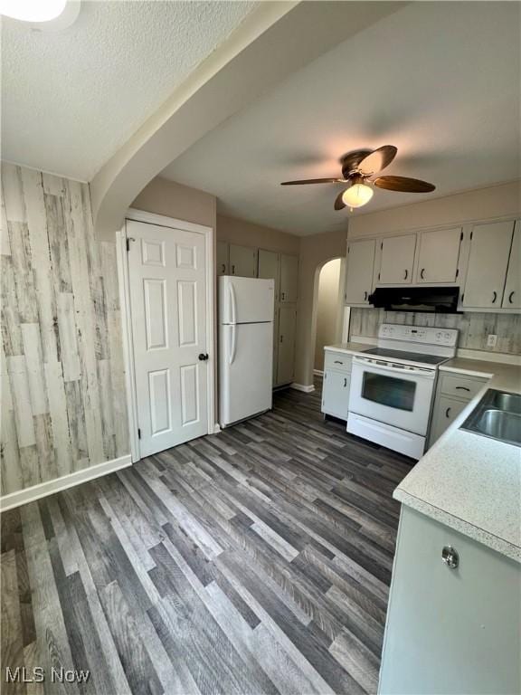 2420 Empire Rd NE, Canton, OH 44705 - kitchen with white appliances, arched walkways, ventilation hood, light countertops, and dark wood-style floors