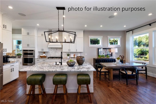 52 Boulder Blvd, Peninsula, OH 44264 - kitchen featuring double oven, custom exhaust hood, decorative backsplash, dark wood finished floors, and recessed lighting
