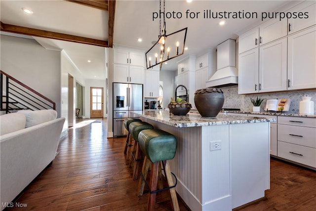 52 Boulder Blvd, Peninsula, OH 44264 - kitchen with stainless steel fridge, custom exhaust hood, dark wood-type flooring, light stone countertops, and recessed lighting