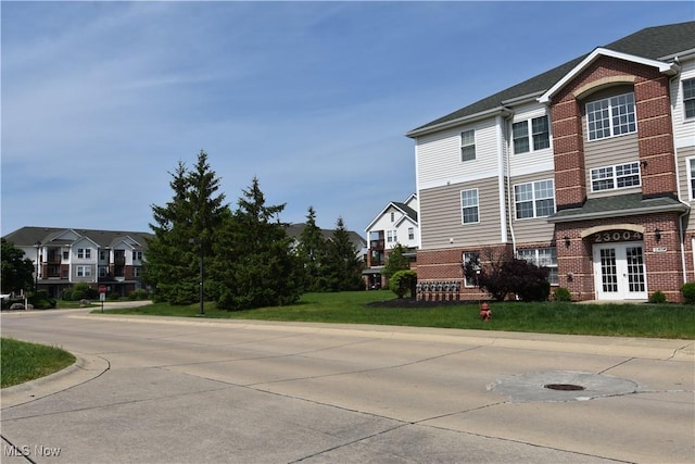 23004 Chandlers Ln Unit 4-344, Olmsted Falls, OH 44138 - view of side of property featuring french doors, brick siding, a residential view, and a lawn