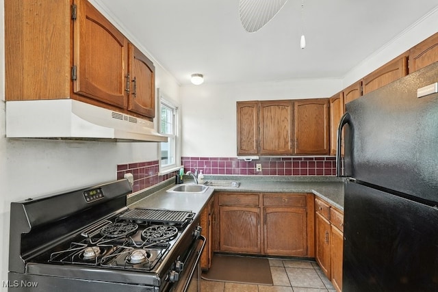 2557 Ogden Ave, Akron, OH 44312 - kitchen with stove, freestanding refrigerator, under cabinet range hood, and brown cabinets