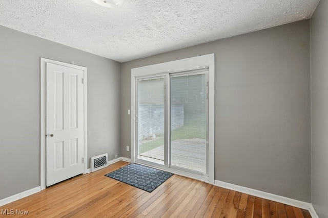 2557 Ogden Ave, Akron, OH 44312 - doorway with hardwood / wood-style flooring and a textured ceiling