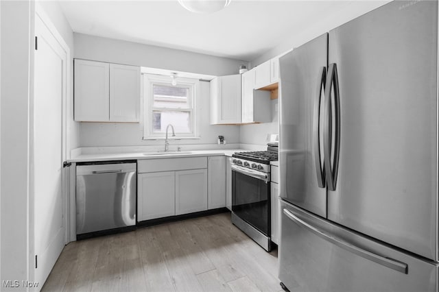922 Winton Ave, Akron, OH 44320 - kitchen with appliances with stainless steel finishes, light wood finished floors, light countertops, and white cabinetry