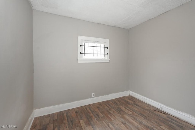 3569 E 154th St, Cleveland, OH 44120 - spare room featuring dark wood-style flooring and a textured ceiling