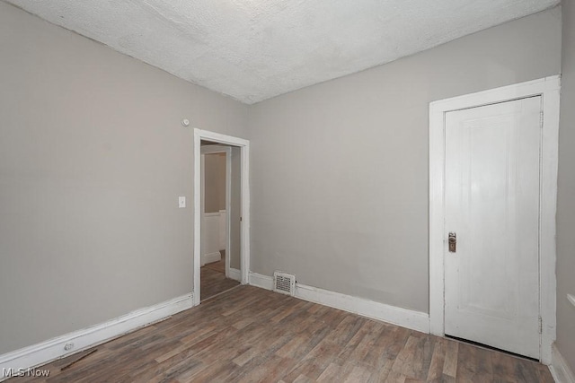 3569 E 154th St, Cleveland, OH 44120 - empty room with wood finished floors and a textured ceiling
