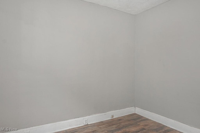 3569 E 154th St, Cleveland, OH 44120 - unfurnished room with dark wood-type flooring and a textured ceiling