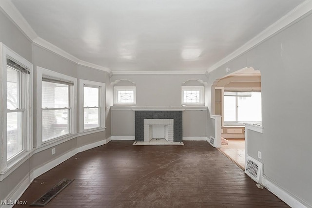 3569 E 154th St, Cleveland, OH 44120 - unfurnished living room with ornamental molding, a brick fireplace, arched walkways, and dark wood-type flooring