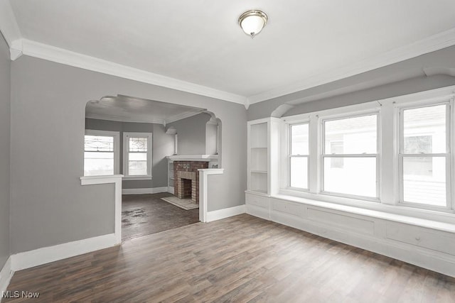 3569 E 154th St, Cleveland, OH 44120 - unfurnished living room featuring arched walkways, ornamental molding, wood finished floors, and a fireplace
