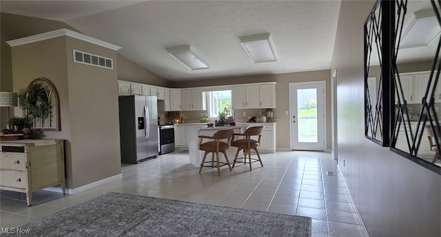2359 Schellin Rd, Wooster, OH 44691 - kitchen featuring appliances with stainless steel finishes, a kitchen breakfast bar, light tile patterned flooring, lofted ceiling, and white cabinetry