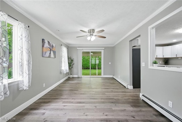 5417 Edgewood Dr, Lorain, OH 44053 - empty room with a baseboard heating unit, a textured ceiling, healthy amount of natural light, and crown molding