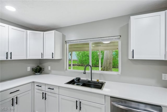 5417 Edgewood Dr, Lorain, OH 44053 - kitchen with stainless steel dishwasher, white cabinets, light countertops, and recessed lighting