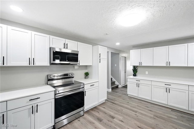 5417 Edgewood Dr, Lorain, OH 44053 - kitchen with stainless steel appliances, recessed lighting, white cabinetry, light countertops, and light wood finished floors