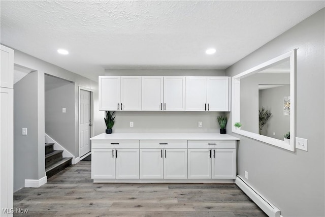 5417 Edgewood Dr, Lorain, OH 44053 - kitchen featuring baseboard heating, recessed lighting, light countertops, white cabinets, and light wood-type flooring