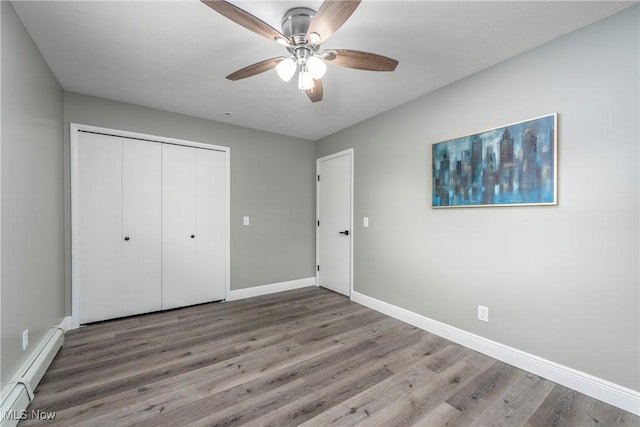 5417 Edgewood Dr, Lorain, OH 44053 - unfurnished bedroom with a baseboard radiator, wood finished floors, a closet, and a ceiling fan