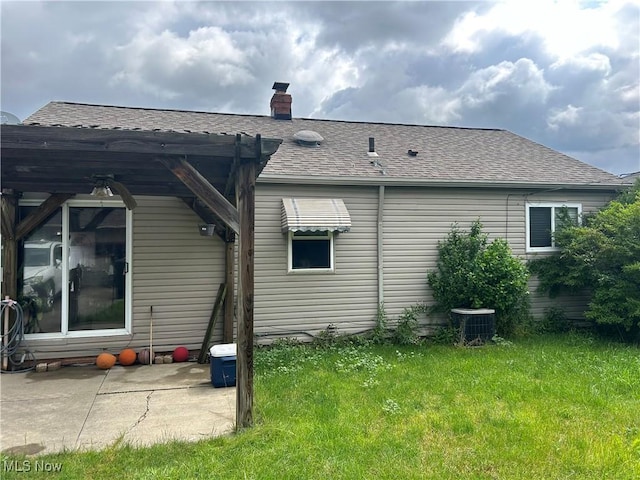 15616 Greendale Rd, Maple Heights, OH 44137 - back of property featuring a yard, a chimney, a shingled roof, and a patio area