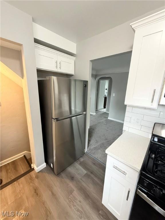 450 E 255th St, Euclid, OH 44132 - kitchen with freestanding refrigerator, range with gas cooktop, arched walkways, light countertops, and white cabinetry