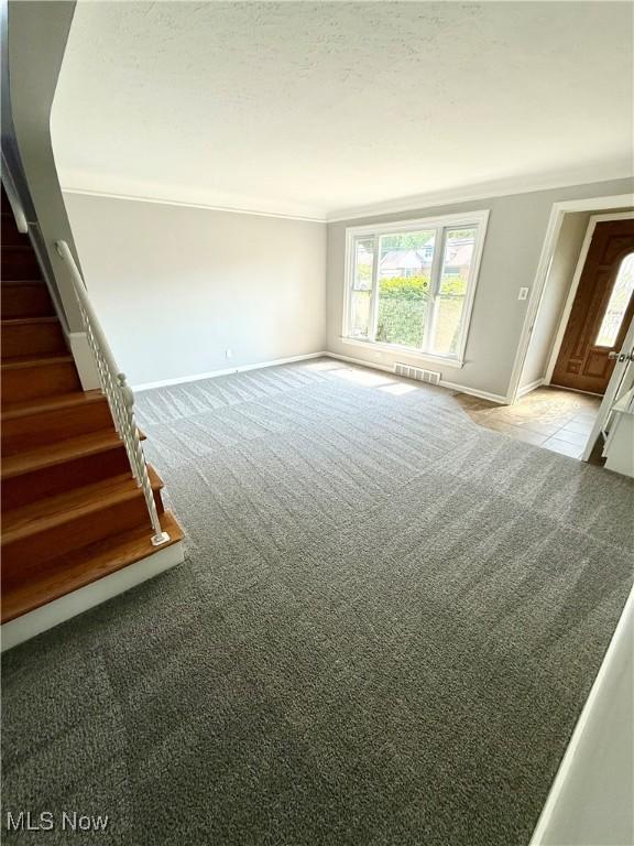 450 E 255th St, Euclid, OH 44132 - unfurnished living room featuring carpet flooring, healthy amount of natural light, stairs, and crown molding