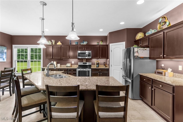 3202 S Lipkey Rd, North Jackson, OH 44451 - kitchen featuring appliances with stainless steel finishes, dark brown cabinetry, light tile patterned floors, hanging light fixtures, and a kitchen breakfast bar