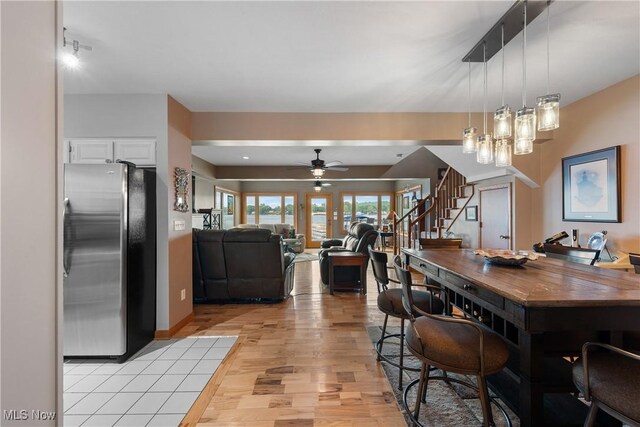 4869 Coleman Dr, Akron, OH 44319 - dining room featuring light wood finished floors, stairs, and ceiling fan