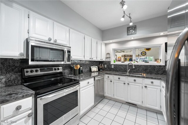 4869 Coleman Dr, Akron, OH 44319 - kitchen with stainless steel appliances, decorative backsplash, light tile patterned flooring, and white cabinetry
