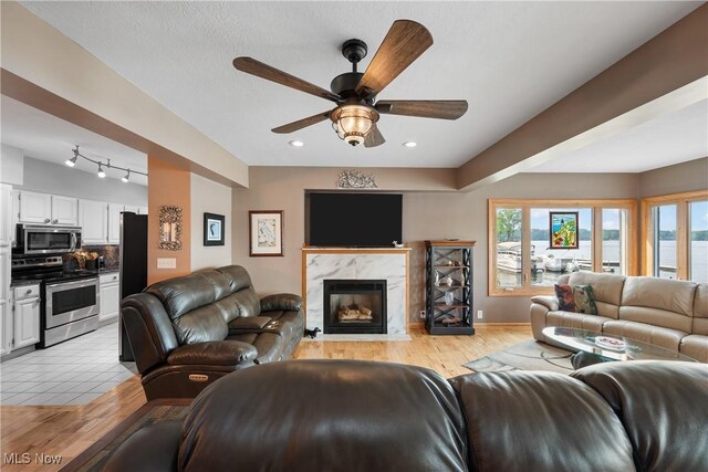 4869 Coleman Dr, Akron, OH 44319 - living room featuring ceiling fan, a premium fireplace, recessed lighting, rail lighting, and light wood finished floors