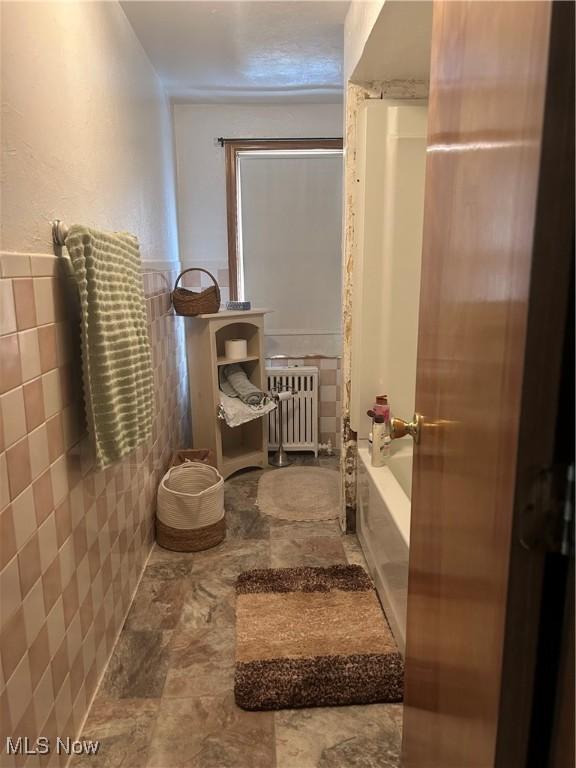 3601 State St, Weirton, WV 26062 - full bath with radiator heating unit, tile walls, and stone finish floors