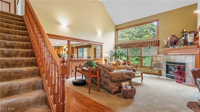 14751 Lancelot Ln E, North Royalton, OH 44133 - living area featuring high vaulted ceiling, stairway, a tiled fireplace, and wood finished floors