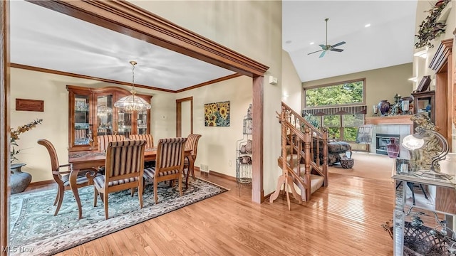 14751 Lancelot Ln E, North Royalton, OH 44133 - dining area featuring hardwood / wood-style flooring, ceiling fan, a fireplace, high vaulted ceiling, and a chandelier