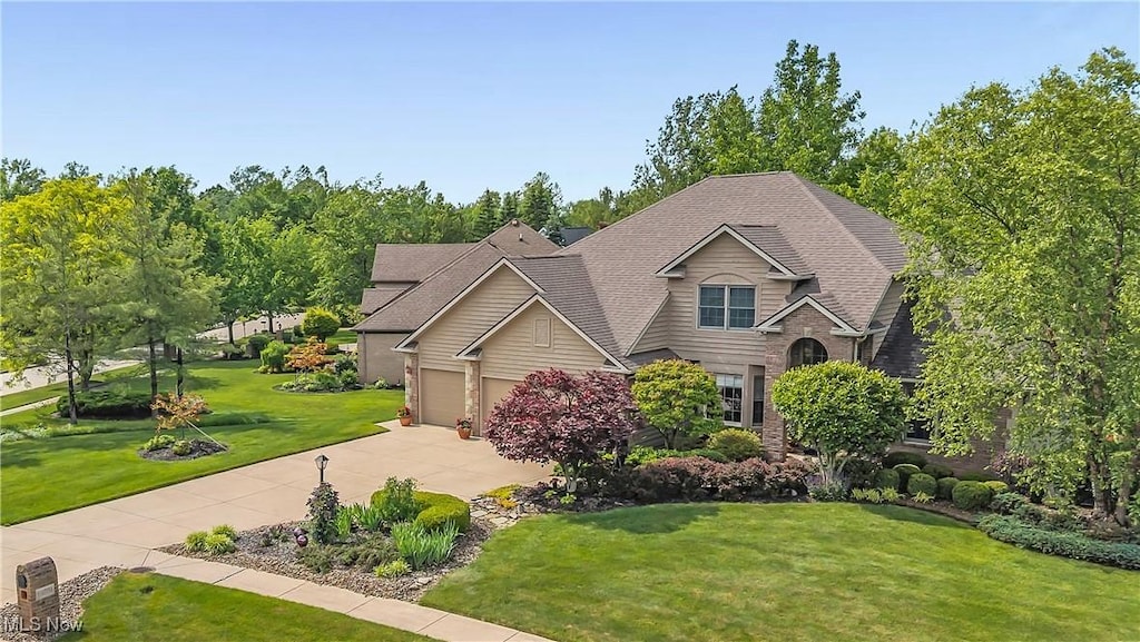 14751 Lancelot Ln E, North Royalton, OH 44133 - view of front of house with a front lawn, driveway, an attached garage, and a shingled roof