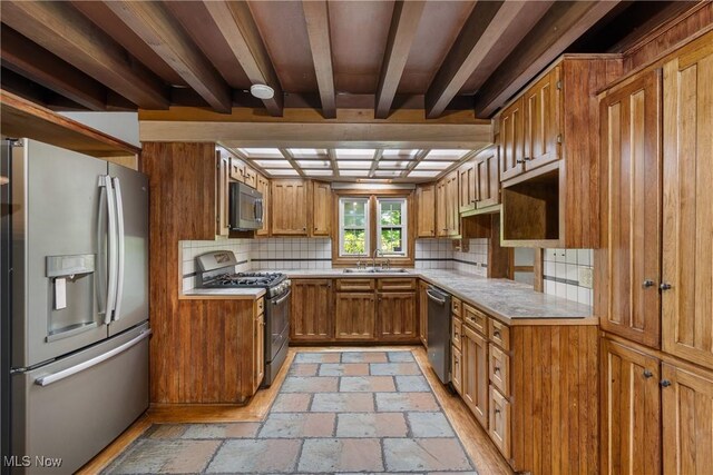 2132 Martin Rd, Mogadore, OH 44260 - kitchen with stainless steel appliances, brown cabinetry, backsplash, stone tile floors, and light countertops