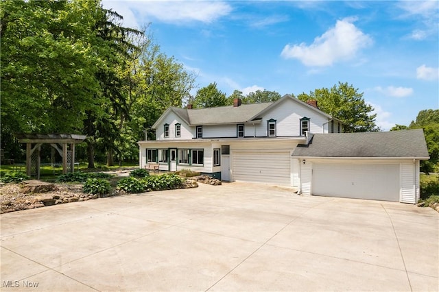 2132 Martin Rd, Mogadore, OH 44260 - view of front of house featuring concrete driveway, a garage, a pergola, and a chimney