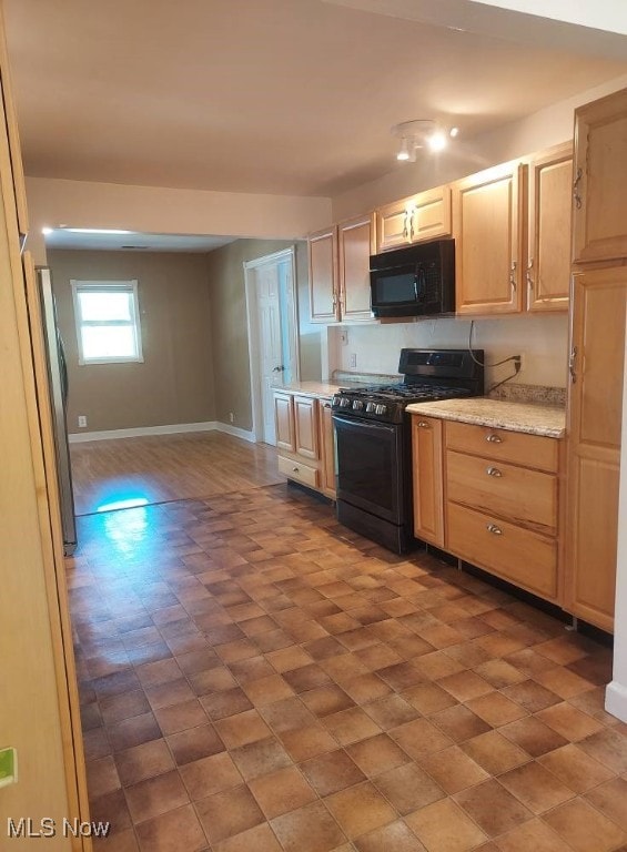 300 37th St, Vienna, WV 26105 - kitchen featuring black appliances, light brown cabinetry, and light stone countertops