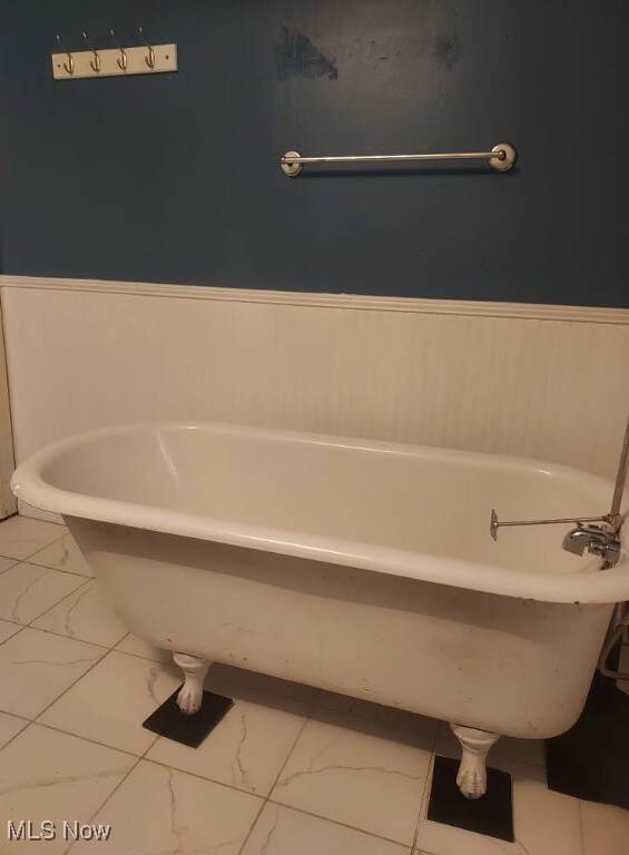 300 37th St, Vienna, WV 26105 - bathroom featuring marble finish flooring, a freestanding tub, and a wainscoted wall