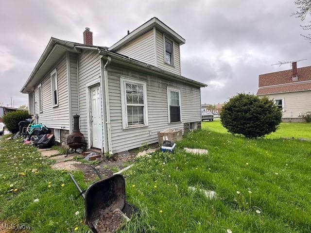 6108 Gateway Blvd S, Elyria, OH 44035 - view of side of home featuring a chimney and a yard