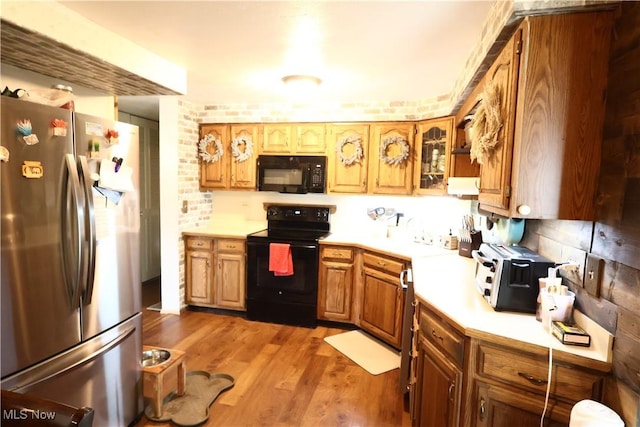 148 Summerberry Ln, Niles, OH 44446 - kitchen with black appliances, light countertops, light wood-type flooring, brown cabinets, and glass insert cabinets