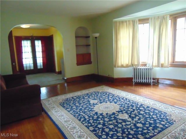 4017 N Ridge Rd W, Saybrook, OH 44004 - living room featuring radiator, arched walkways, and wood finished floors