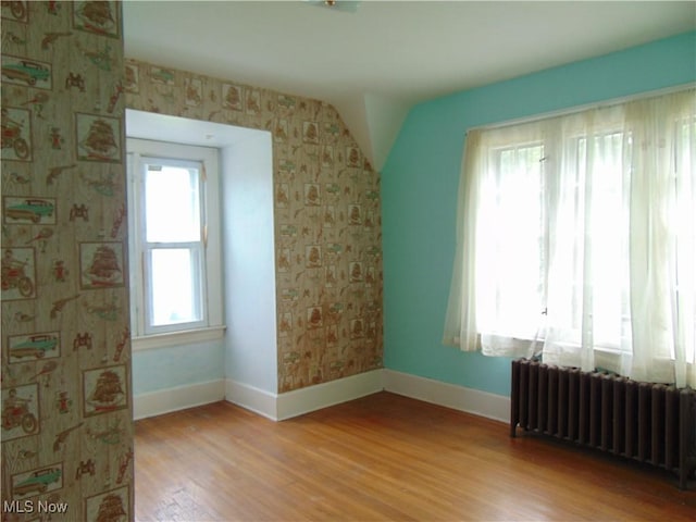 4017 N Ridge Rd W, Saybrook, OH 44004 - empty room with radiator heating unit, wood finished floors, and wallpapered walls
