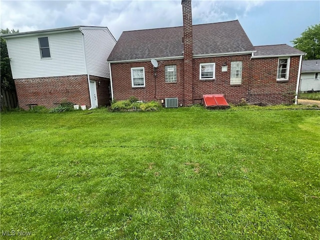 530 Center St, Hubbard, OH 44425 - rear view of property featuring brick siding, a chimney, and a lawn