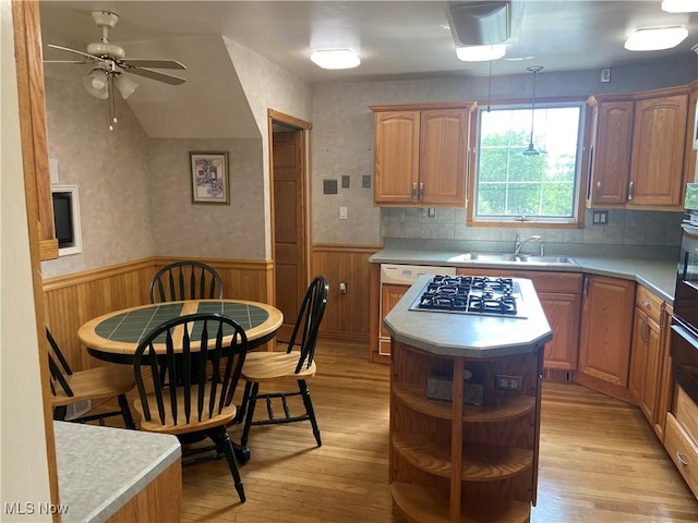4520 E Wallings Rd, Broadview Heights, OH 44147 - kitchen with gas cooktop, light wood-style floors, wainscoting, a ceiling fan, and a kitchen island