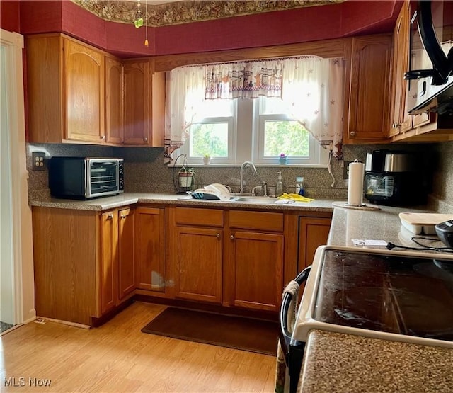 67966 Old Twenty One Rd, Cambridge, OH 43725 - kitchen with electric range, brown cabinets, light wood finished floors, and decorative backsplash