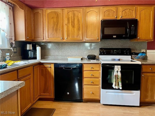 67966 Old Twenty One Rd, Cambridge, OH 43725 - kitchen featuring black appliances, light wood finished floors, brown cabinetry, and light countertops