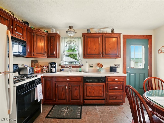 290-289 Park Ave, Conneaut, OH 44030 - kitchen with gas stove, paneled dishwasher, freestanding refrigerator, black microwave, and healthy amount of natural light